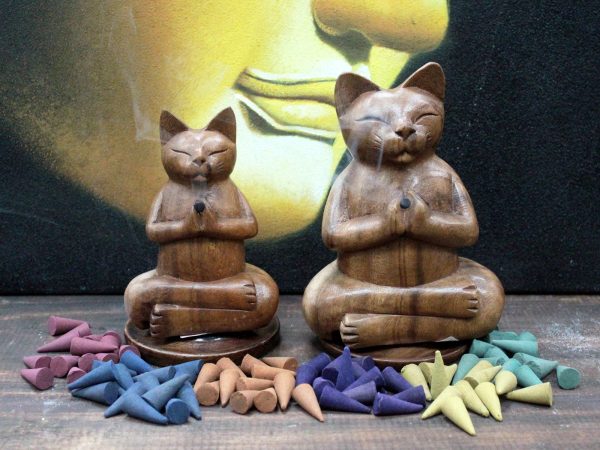 light the tip of the cone with a match or lighter and place our Wooden Yoga Cat on top of it. The smoke will find the way out through the cats' paws.